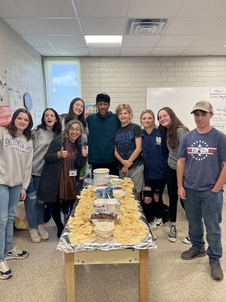 Classroom celebration highlighting collaboration in moving from intermediate to advanced English.