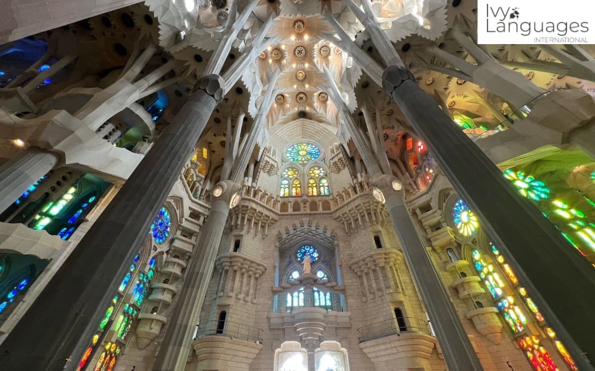 Daily habits for intermediate fluency include English immersion abroad while exploring Sagrada Familia's stained glass interior