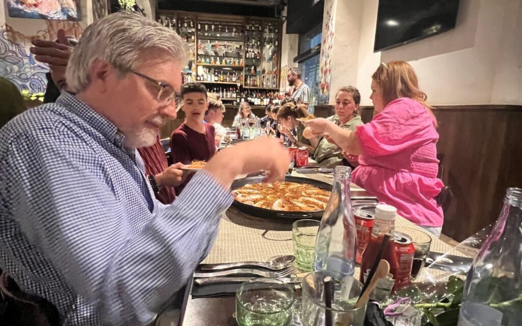 Students building natural English communication and advanced English speaking skills during immersive group dinner abroad 