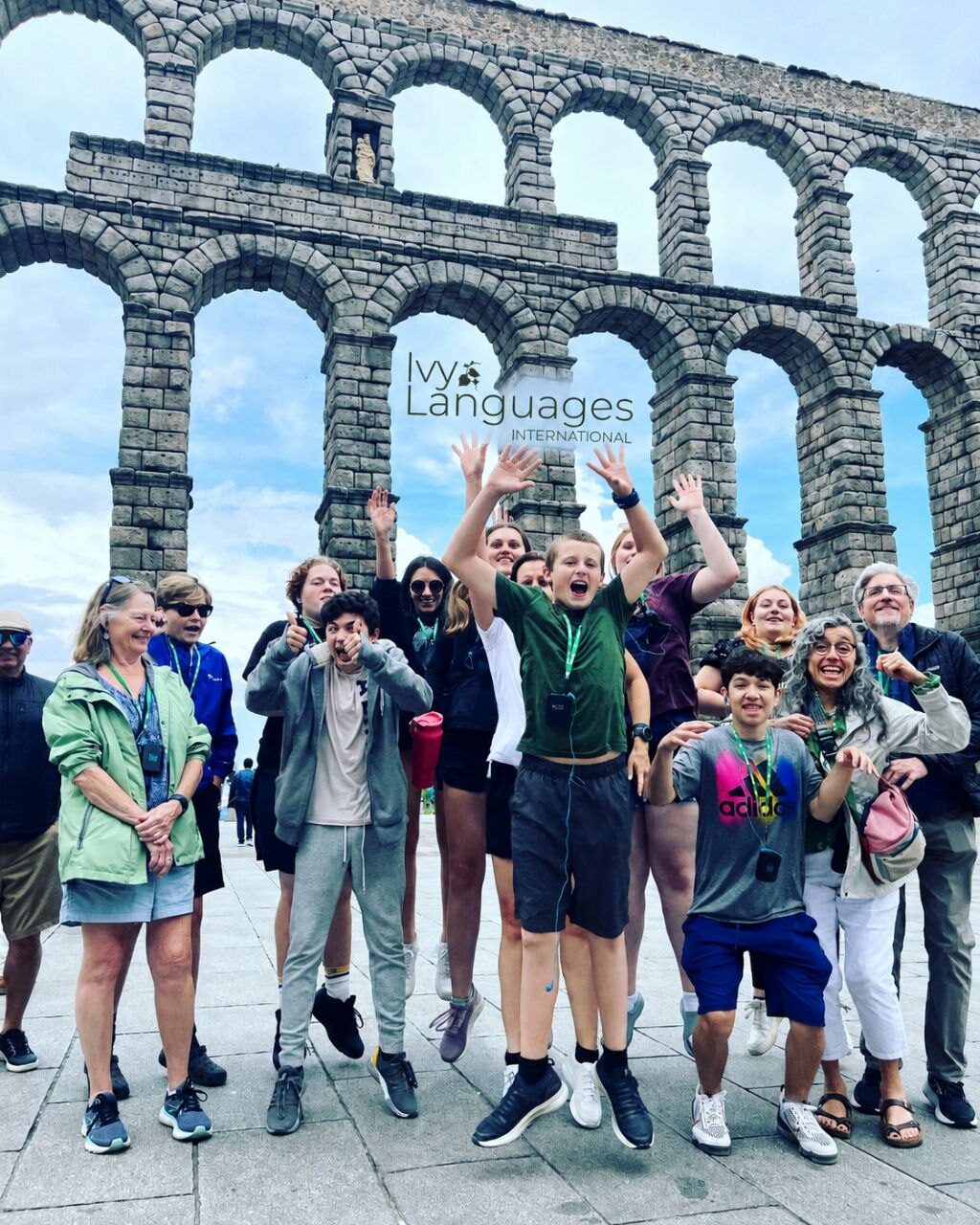 Students practicing complex sentence structures in Spanish during an exciting group trip to the Roman Aqueduct of Segovia.