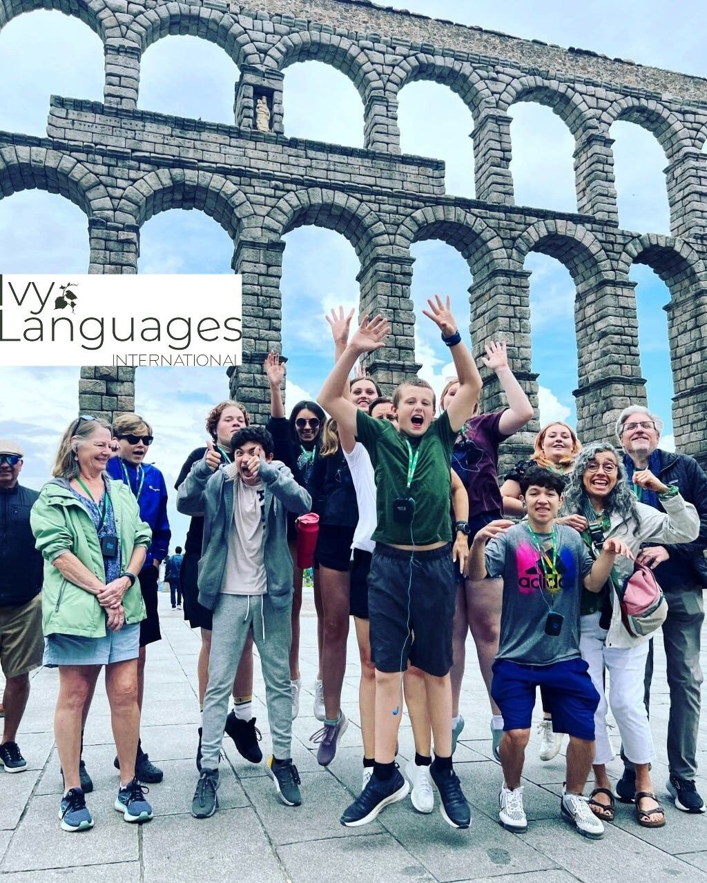 Students practicing complex sentence structures in Spanish during an exciting group trip to the Roman Aqueduct of Segovia.