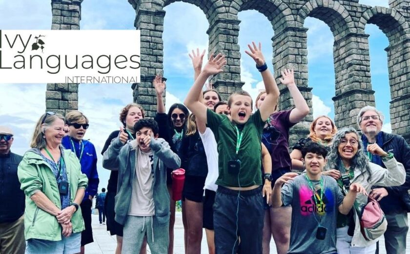 Students practicing complex sentence structures in Spanish during an exciting group trip to the Roman Aqueduct of Segovia.